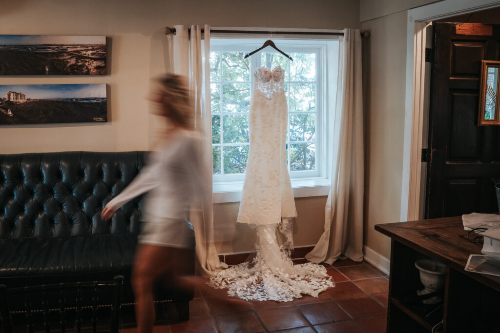 wedding dress by Gown boutique of charleston hanging in the historic rice mill