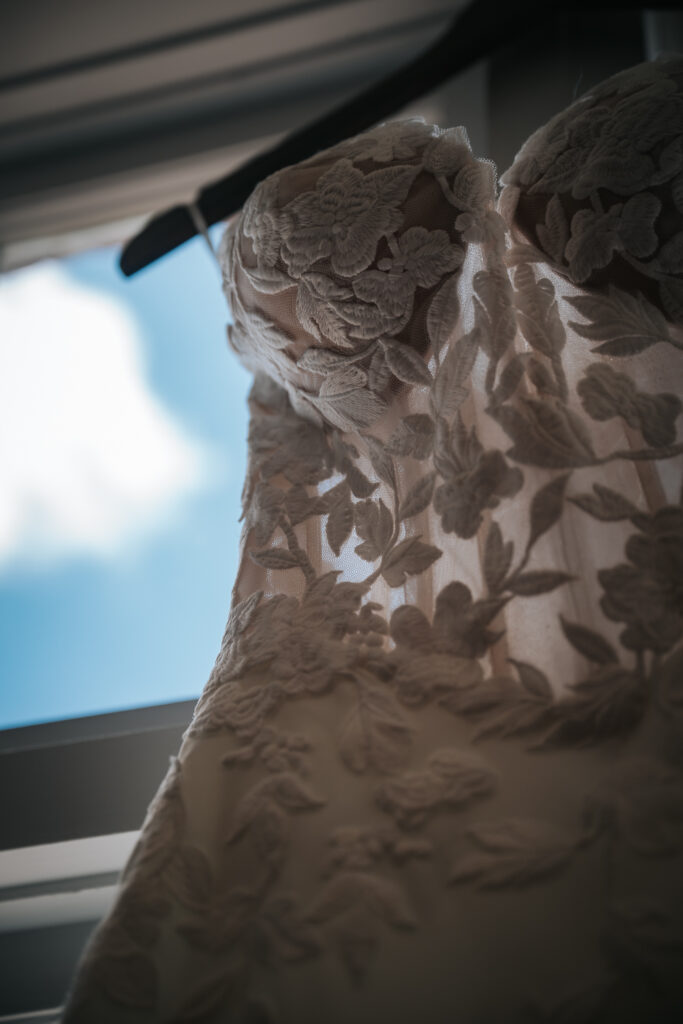 wedding dress by Gown boutique of charleston hanging in the historic rice mill