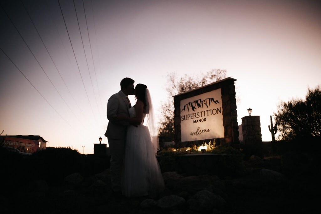 Bride and groom posing in front of the Superstition Mountains after their wedding at Superstition Manor